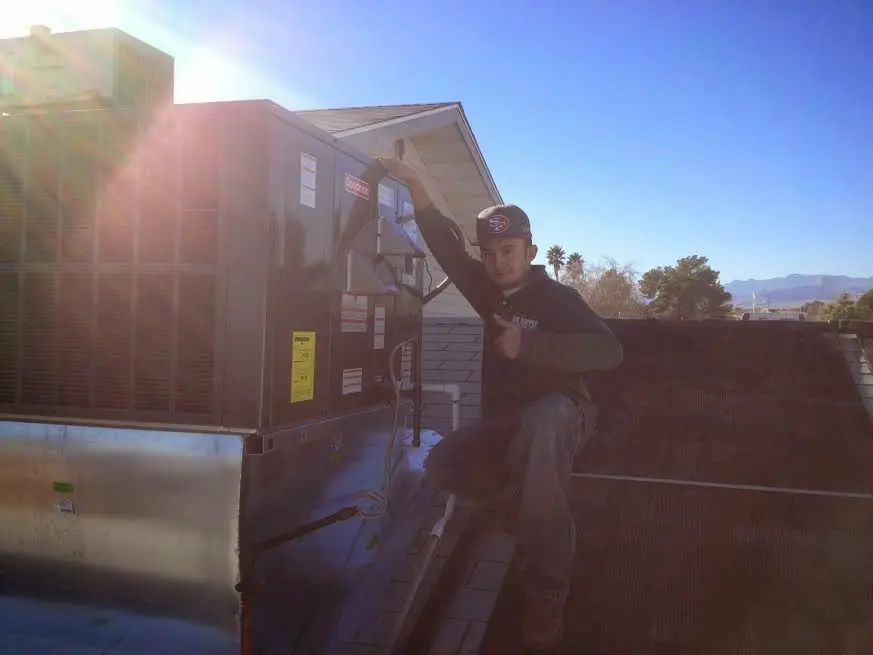 HVAC technician performing AC Tune-Up on a rooftop unit in Swannanoa